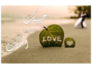 A leaf and the word love on the beach